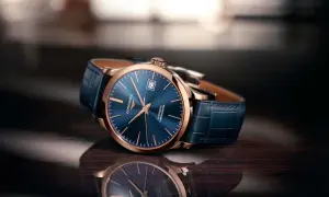 Elegancki zegarek damski rose gold z granatową tarczą i skórzanym paskiem, odbijający się w błyszczącej powierzchni.