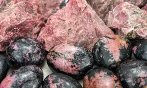 Surowe i polerowane kamienie rodonitu, których znaczenie to kamień miłości i równowagi.