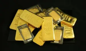 Kupa błyszczących sztabek złota, każda o charakterystycznym, lśniącym połysku. Widać napisy "Fine Gold 999,9" i "1 KILO", które pokazują, jak wygląda złoto w swojej najczystszej formie.