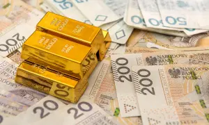 Sztabki złota na tle polskich banknotów. Rozważasz sprzedaż złota? Pamiętaj o podatku!