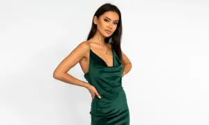 Elegancka kobieta w szmaragdowej sukience z weluru, z delikatną złotą biżuterią do zielonej sukienki.