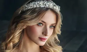 Piękna kobieta z burzą blond włosów, ozdobiona bogato zdobionym diademem ślubnym.