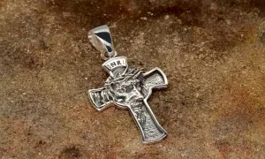 Srebrny krzyżyk męski z wizerunkiem cierpiącej twarzy Jezusa i napisem INRI.