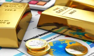 Sztabki złota i monety euro na tle wykresów i kalkulatora symbolizują inwestycję w złoto jako bezpieczną przystań finansową.