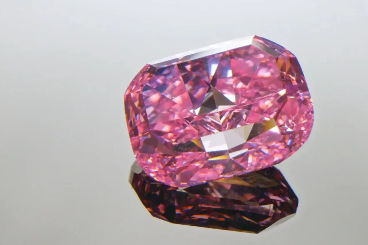 Różowy, fasetowany diament, prawdopodobnie najdroższy diament na świecie, odbija się w lustrzanej powierzchni.